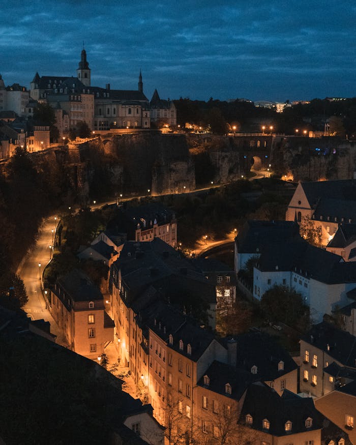 A stunning aerial view of Luxembourg City's historic buildings illuminated against the night sky.