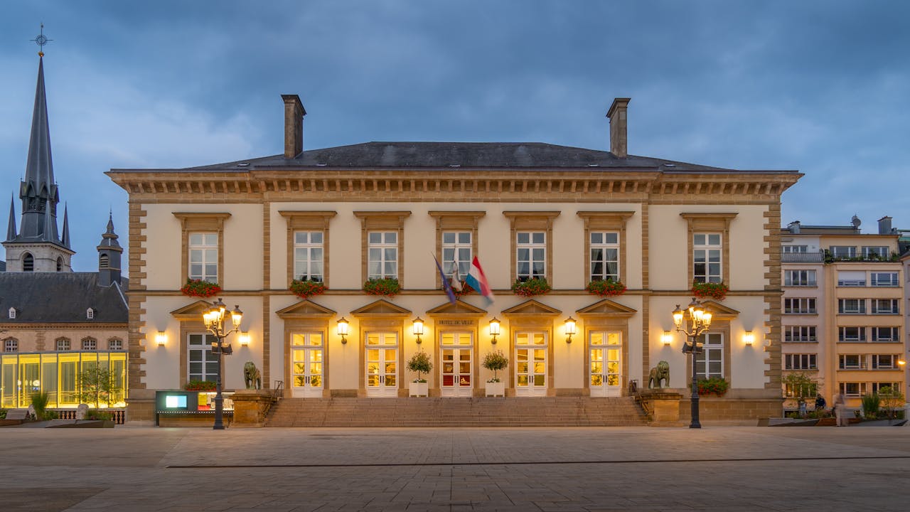 Illuminated historic building in Luxembourg City during blue hour, showcasing classic European architecture.
